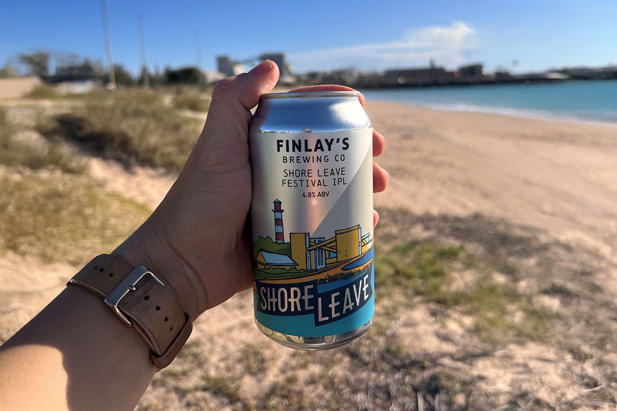 Finlay’s Brewing Co Shore Leave Festival IPL beer can against a scenic beach backdrop.
